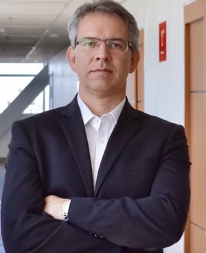 Daniel está olhando para frente e está com os braços cruzados