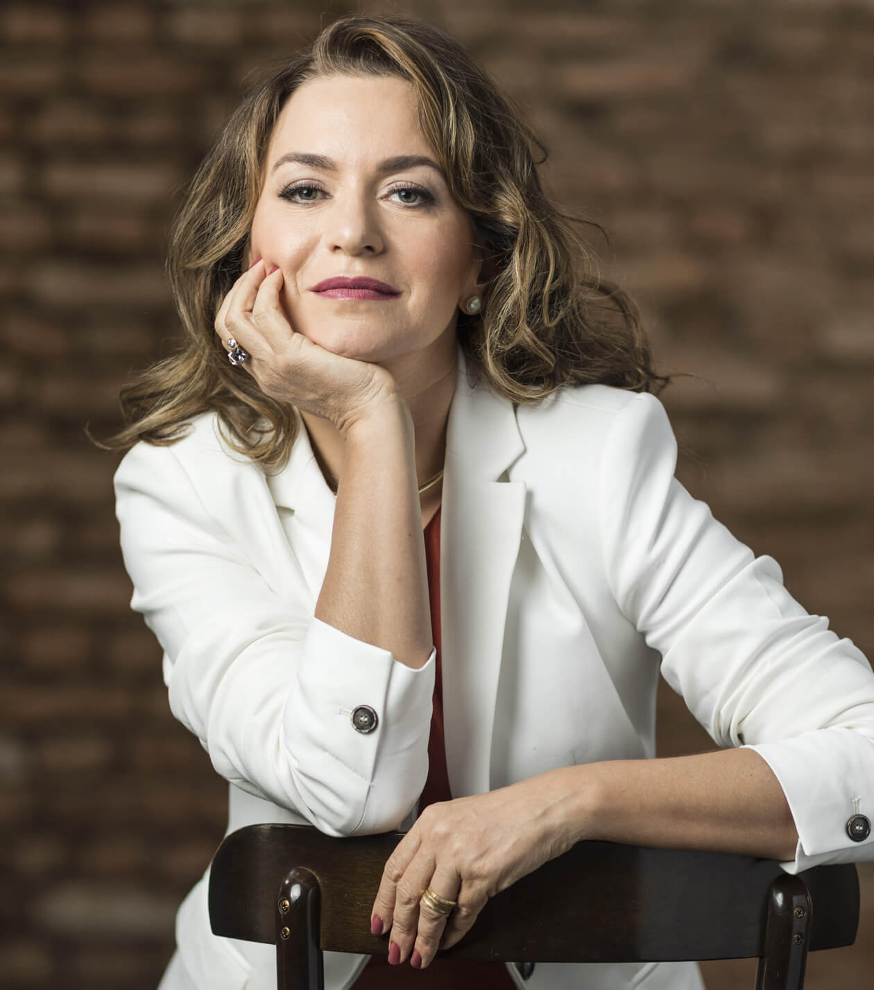 Especialista em comunicação sentada com a mão no rosto.