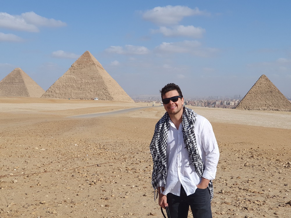Leandro está de pé em frente às pirâmides do Egito